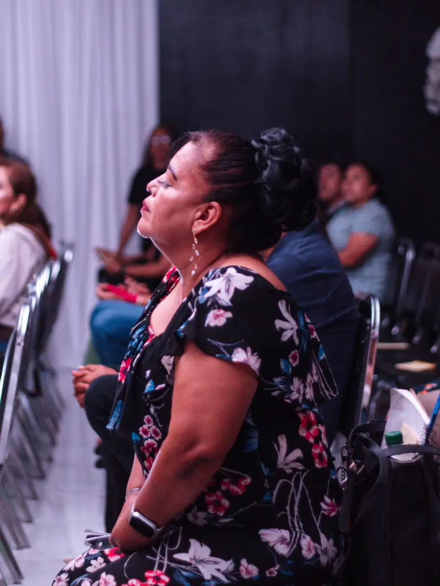 Una mujer alabando durante la reunión